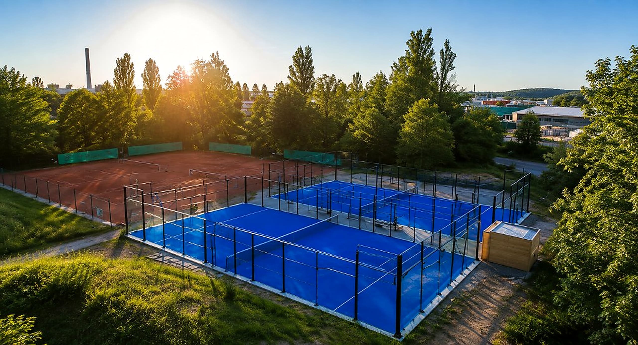 Luftaufnahme bei Sonne — zwei blaue Padelcourts neben den Sandplätzen in Landshut